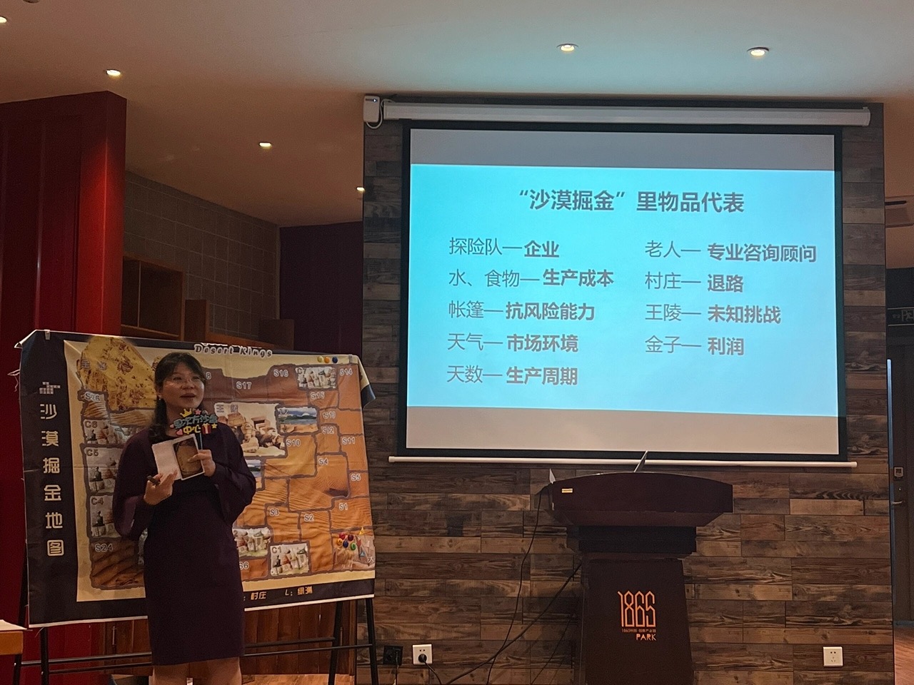 沙漠掘金项目讲师讲解沙盘规则——把探险队比作企业、把水和食物比作生产成本的多组协作推演场景