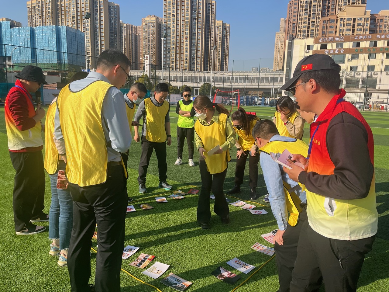 急速60秒项目户外分组游戏——黄色背心队员在足球场分组比拼,户外开阔场地的真实训练