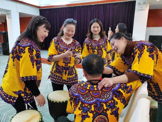 成员围绕同一面鼓互动,动作、节奏与呼应可以一起设计。