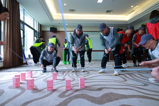 合力筑塔实拍,队员共同控制绳索与吊取装置。